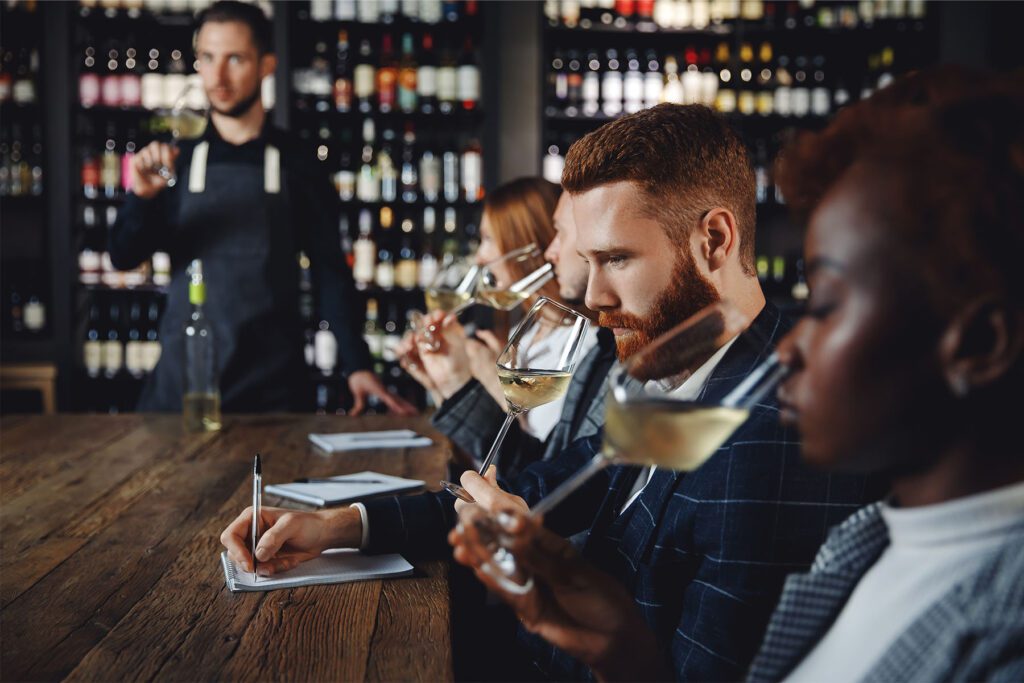 Men and women with a sommelier smelling and tasting wine