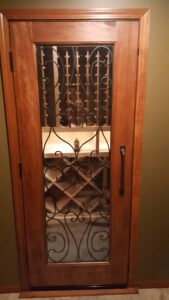 Closed wooden door with a window into a small wine room